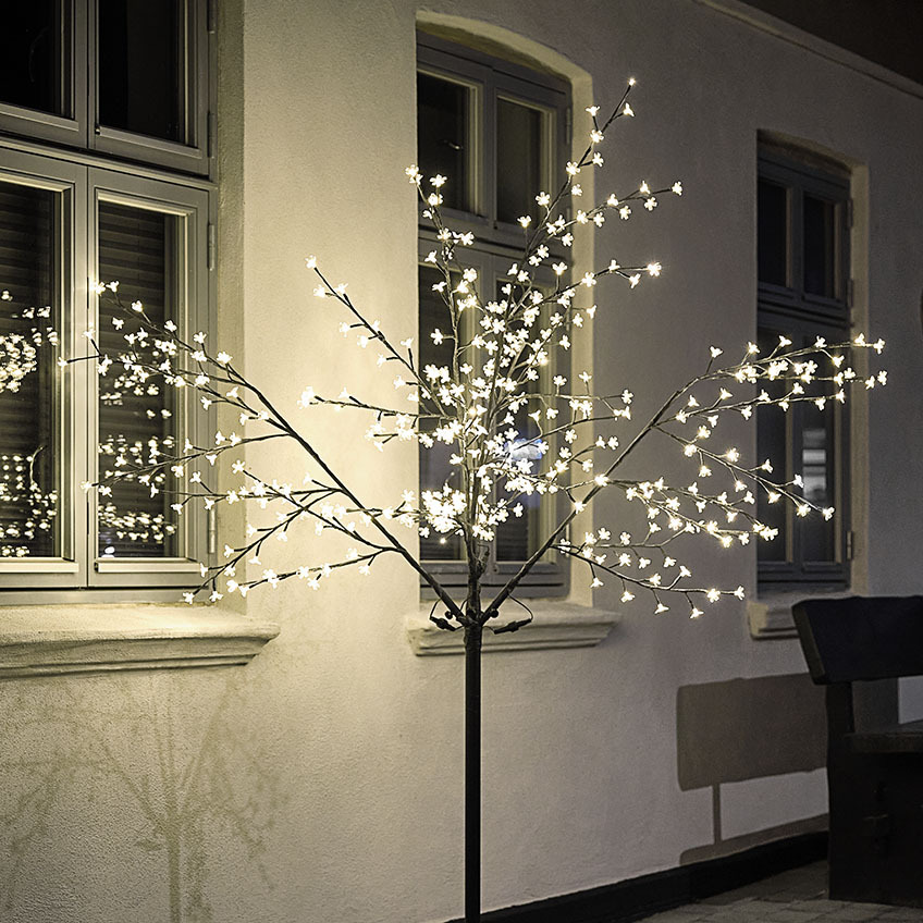 Grande albero di luci a LED che illumina la parete della casa