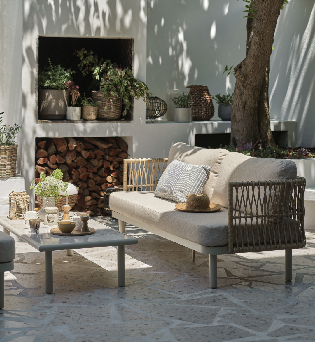 Moderno set lounge per esterni in color beige e grigio ben disposto su terrazza