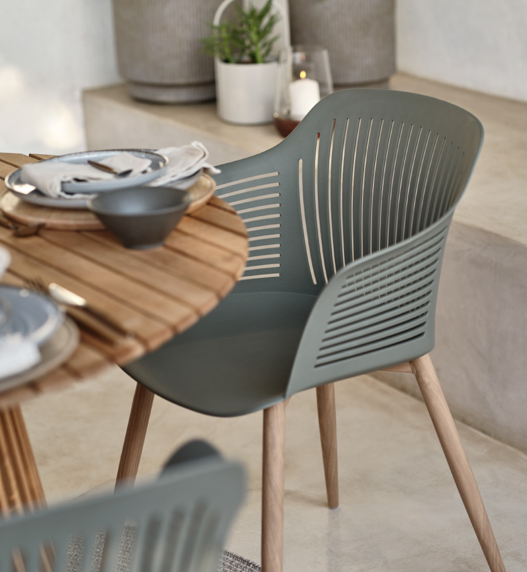 Salle à manger d'extérieur avec table en bois et chaises modernes de couleur olive avec d'accessoires d'extérieur