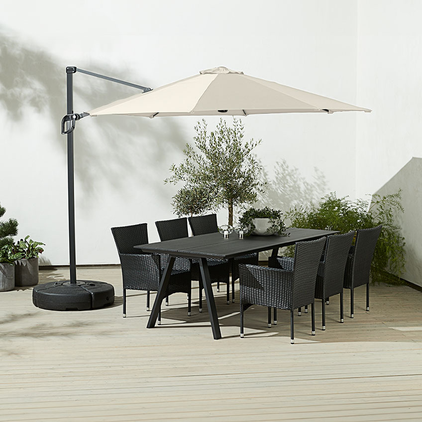 Grosser, quadratischer, cremefarbener Ampelsonnenschirm über einem Esstisch mit Gartenstühlen